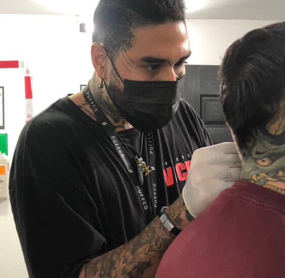 Artista realizando tatuajes en San José en el estudio Armageddon